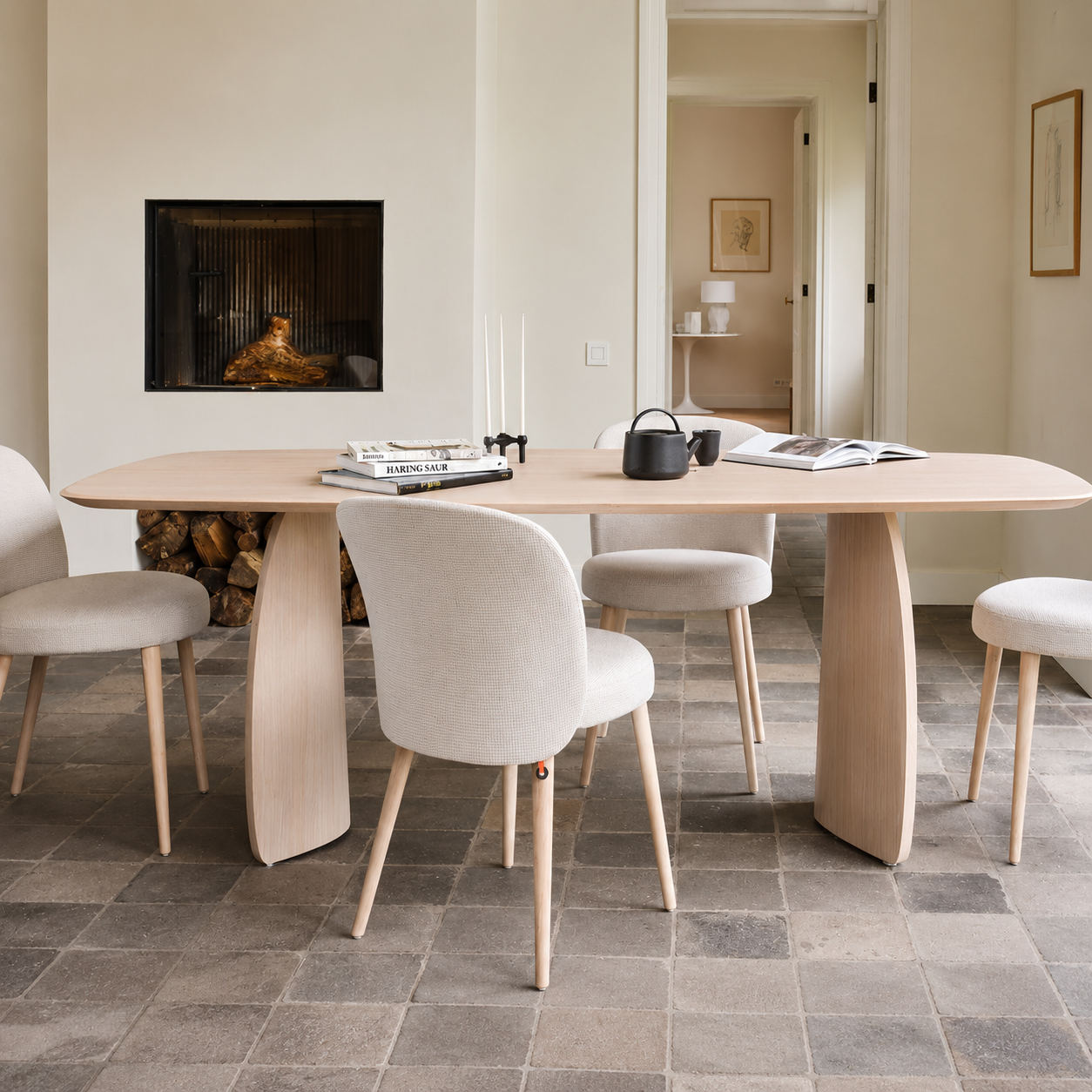 Minimalist dining setting featuring a round wooden table and upholstered chairs by MOBITEC