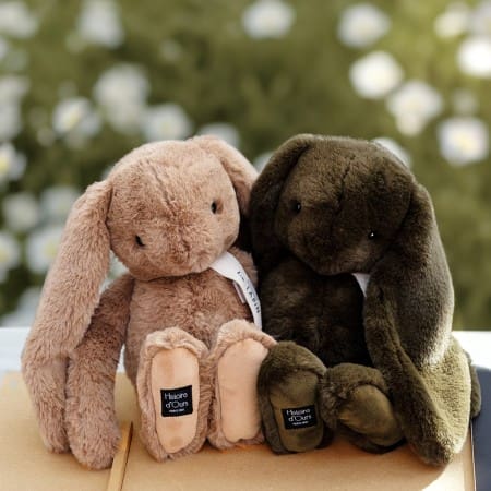 lush bunny toys in soft neutral shades styled in a natural outdoor setting