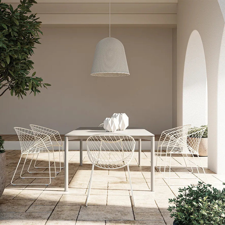 כסאות Bolina עם ידיות בלבן סביב שולחן אוכל, בחצר מקורה עם קשתות